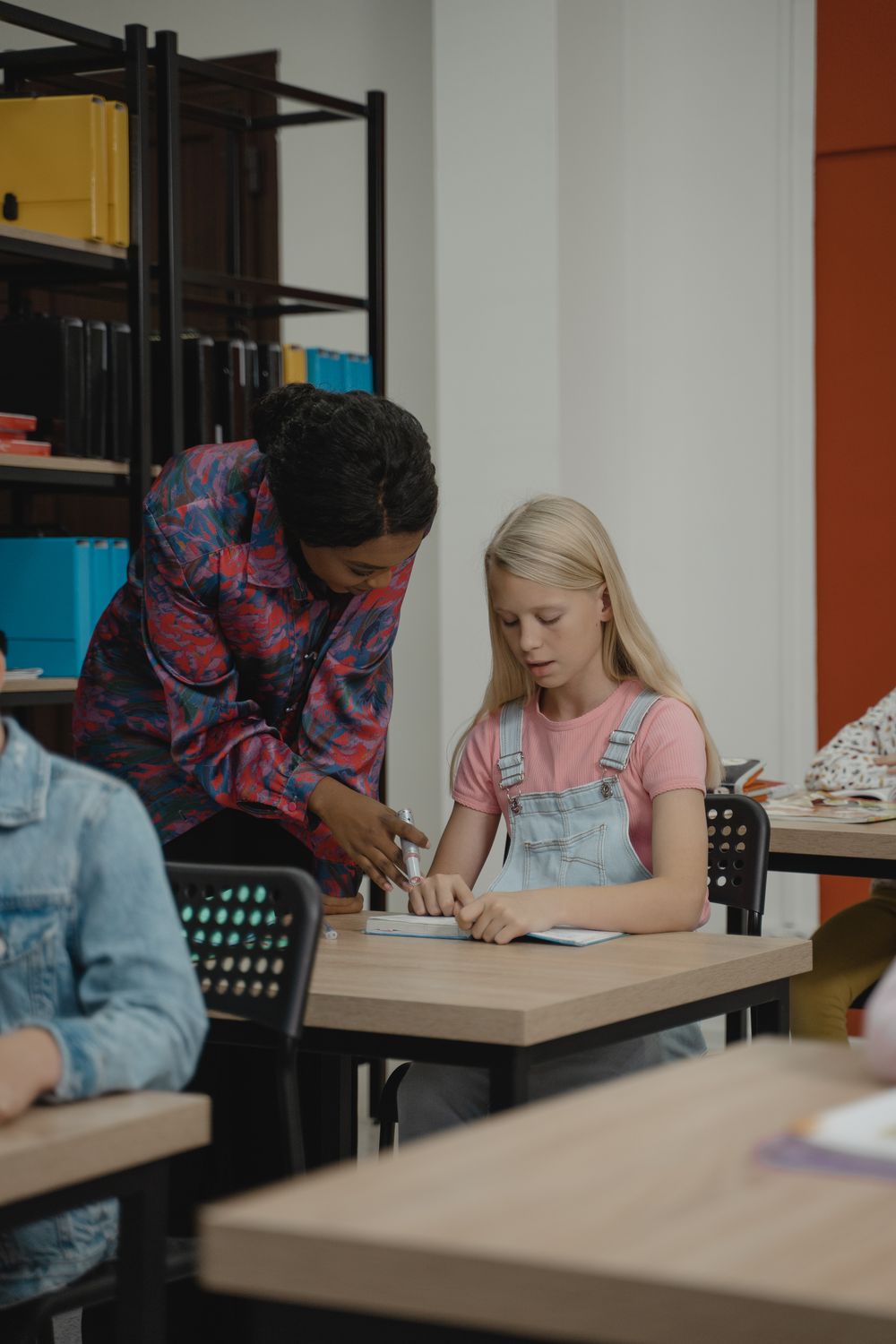 A teacher helping a student with classroom work